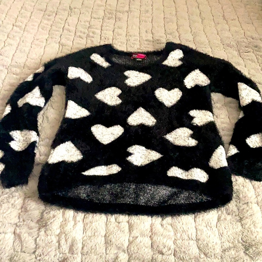 This is a long sleeve black sweater with white heart accents.